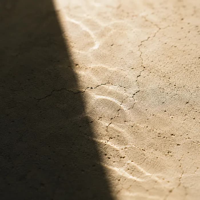 Harsh midday sun burning across cracked stone — standing in for UV exposure.
